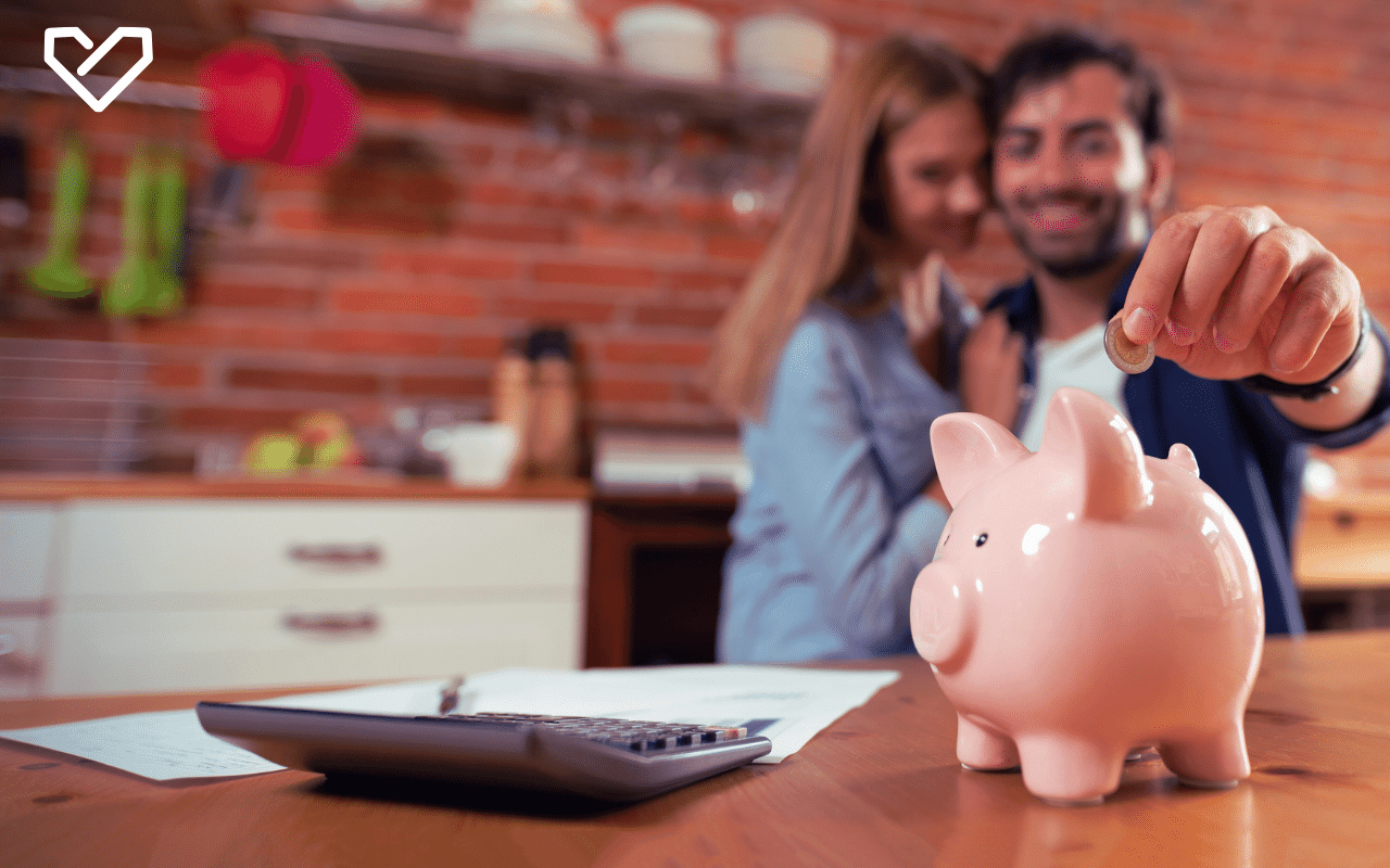couple putting money in piggy bank